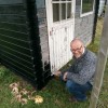 Herman Postma zet het hokje op de schooltuin in de verf